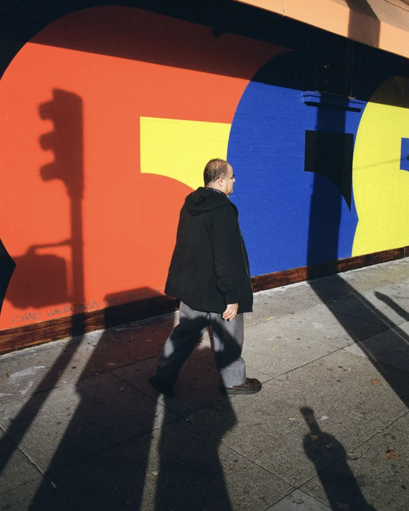A man walking by a painted mural