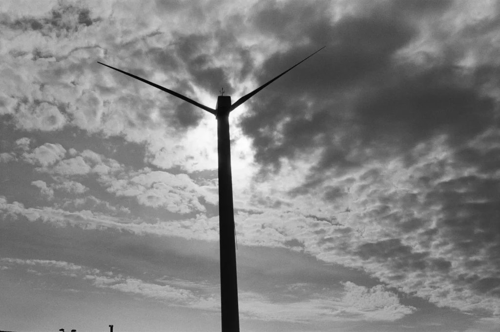 Wind turbine silhouetted against dramatic sky