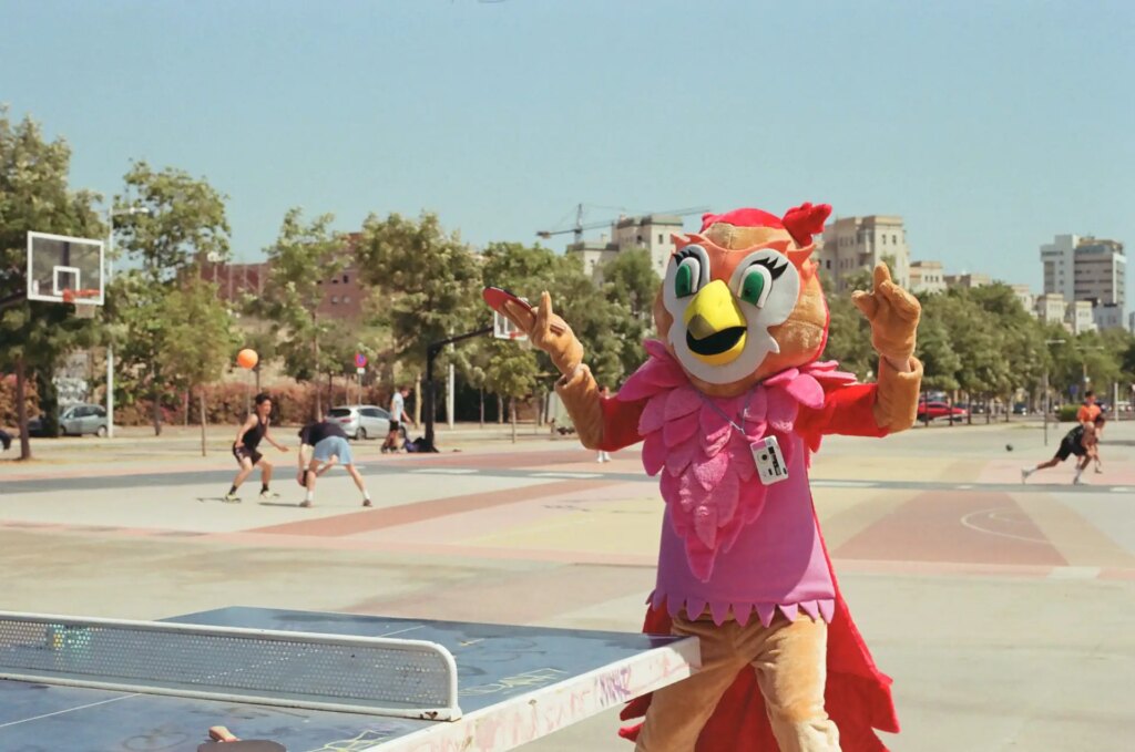 person dressed in animal costume playing ping pong outdoors in the sun
