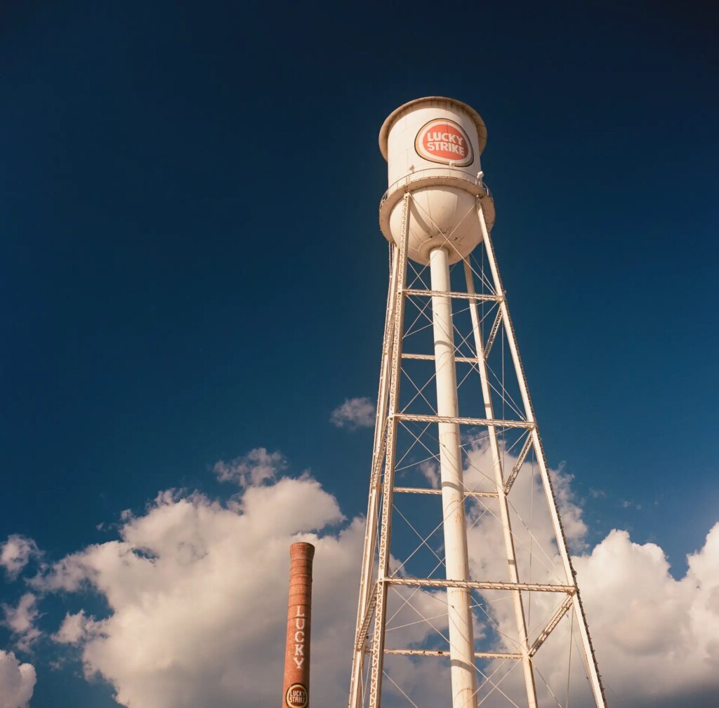 Image of just the Lucky Strike water tower and smoke stack with the camera aimed up into the deep blue sky. 