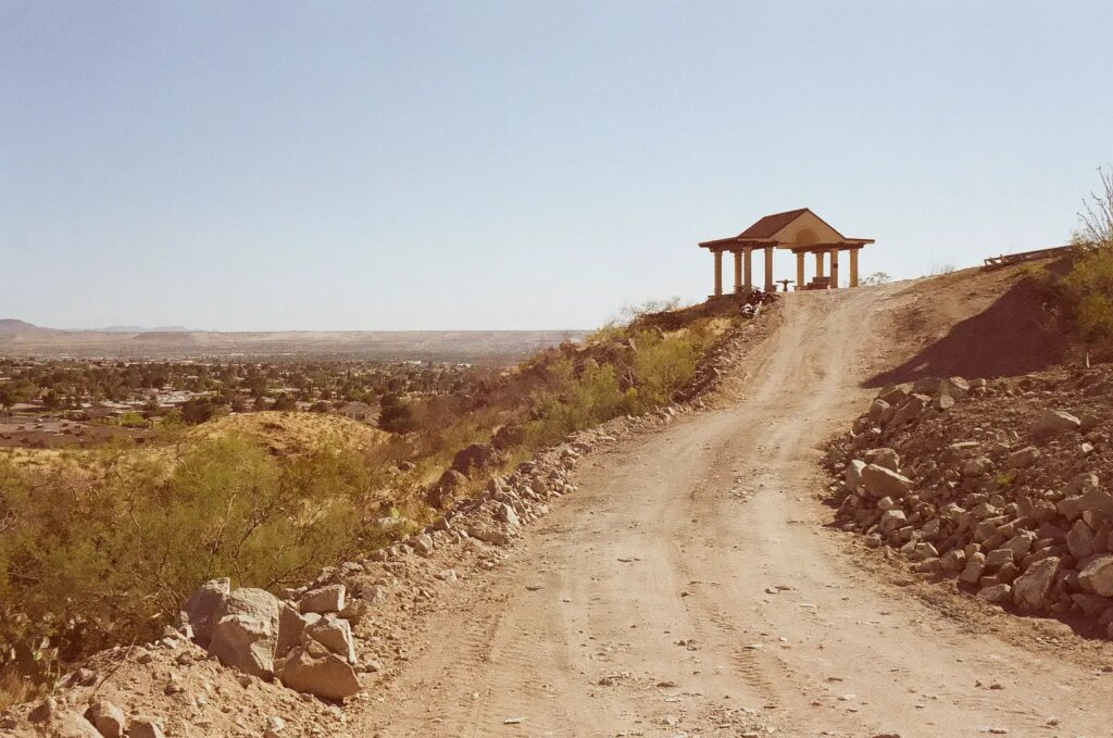 a gazebo on a hill top with a path leading up to it.