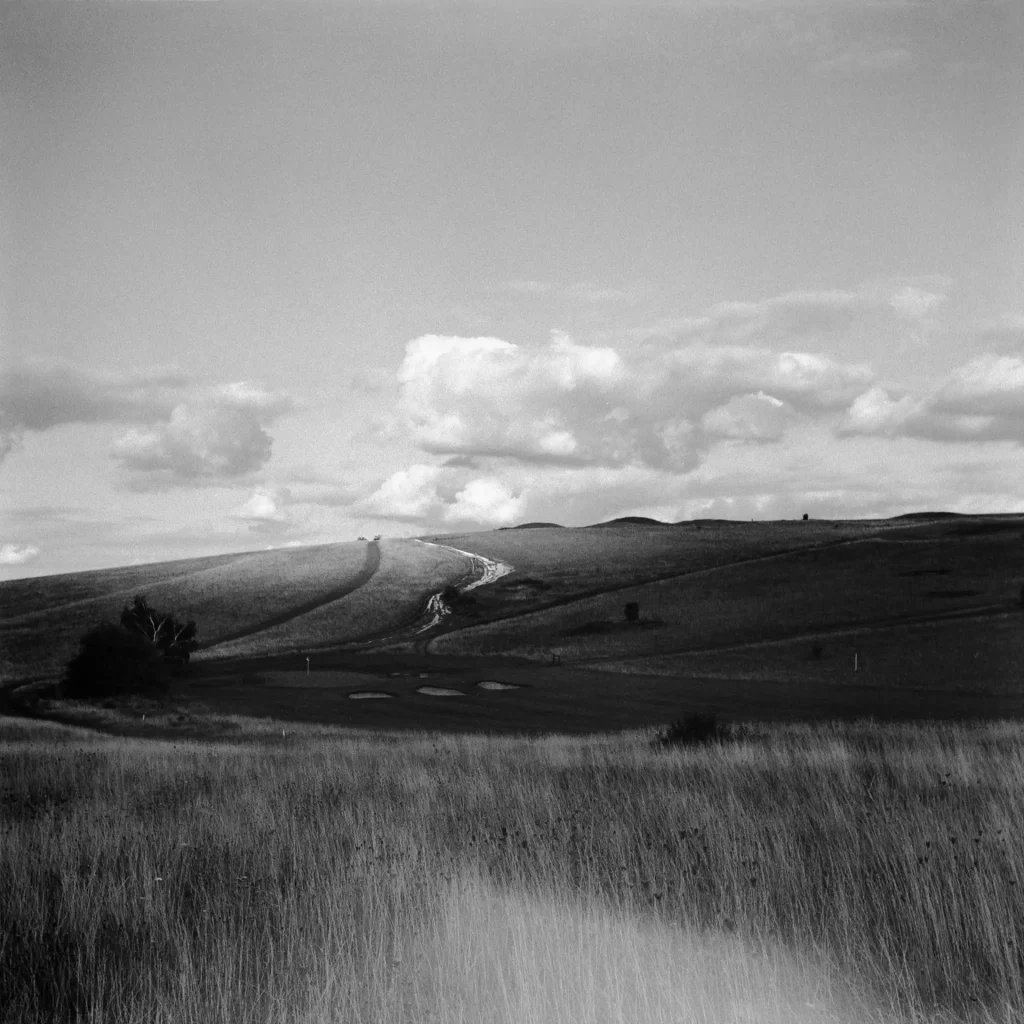 Grassland and a hill with a prominent light leak in the bottom of the frame