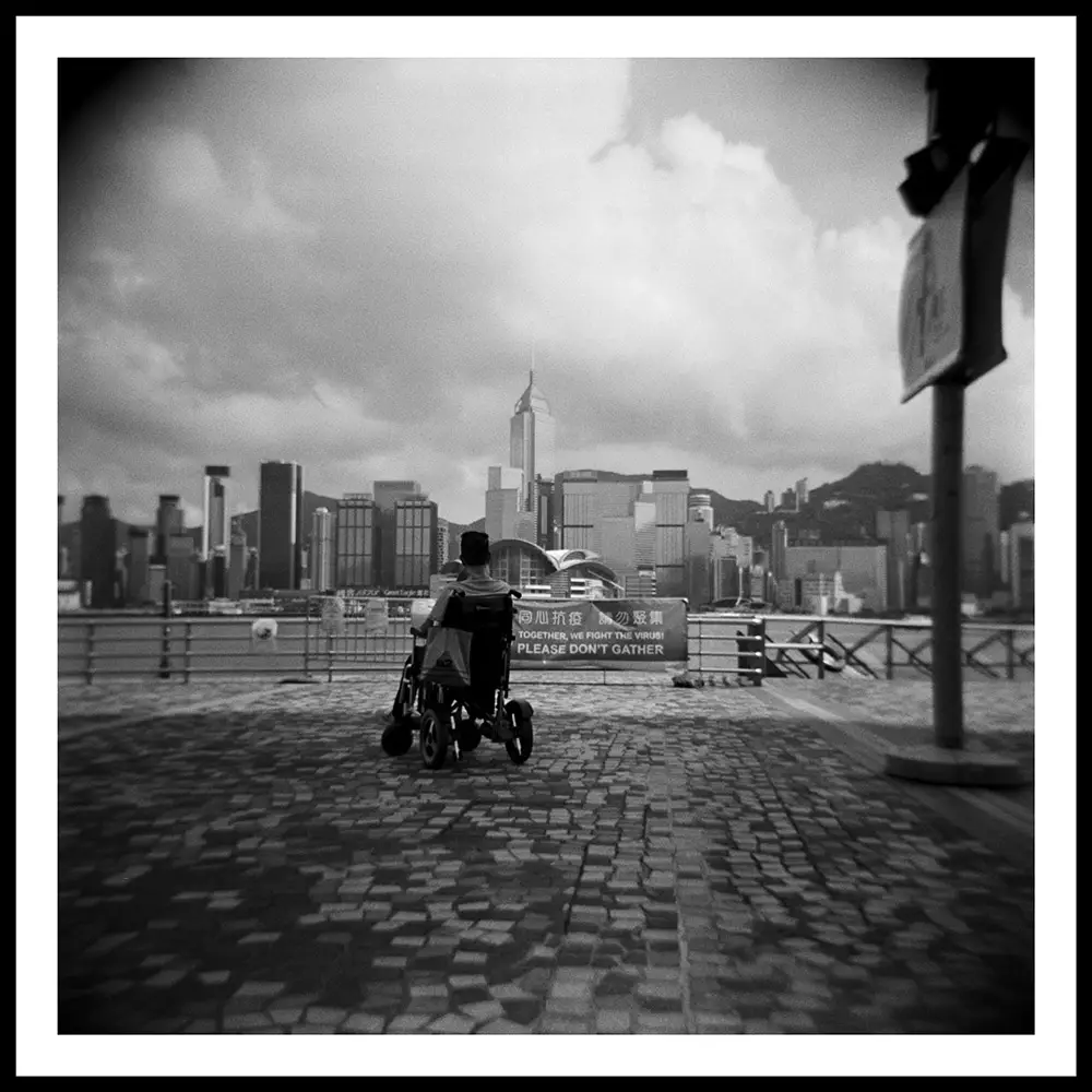 man in a wheelchair looking out on a large city