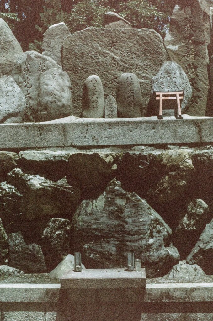 A shrine made of large rocks with a single miniature torii gate