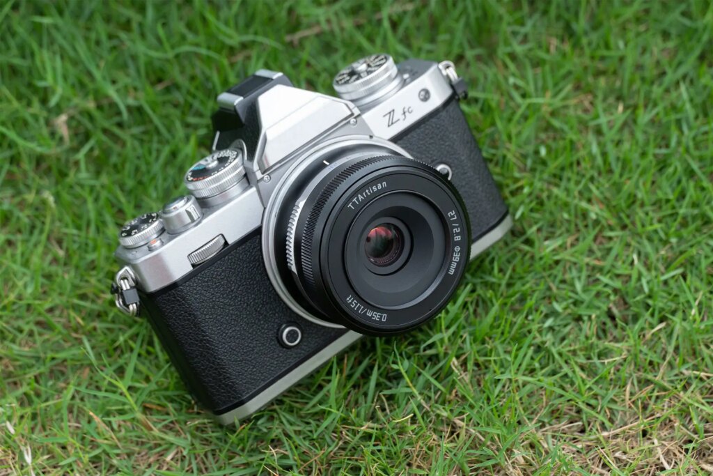 Nikon Z Mount camera with the 27mm F2.8 laying in the grass