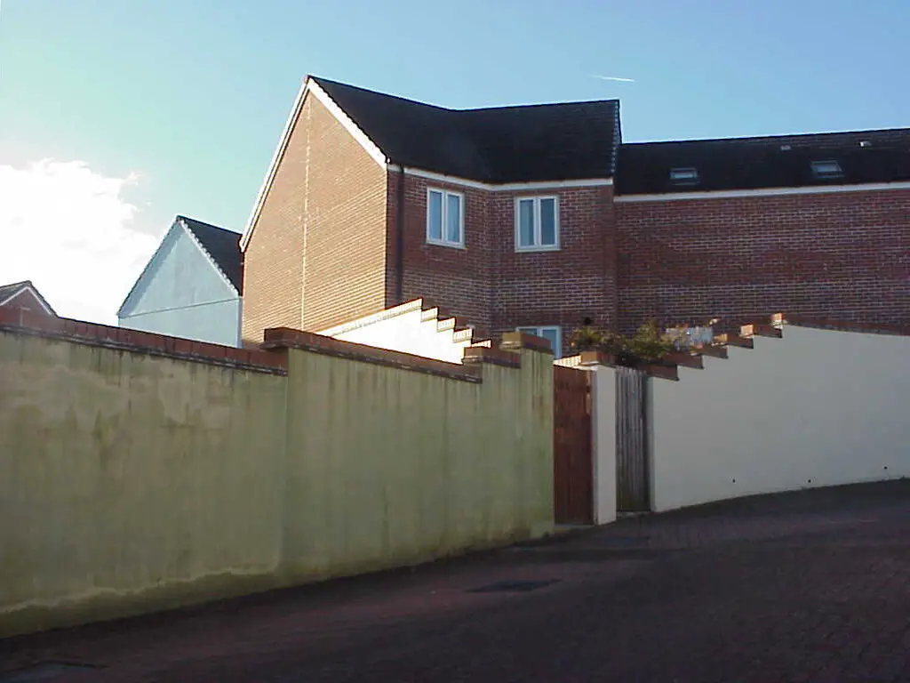 A house with a wall with a red gate