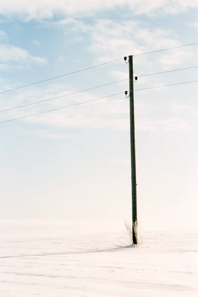 Photo of a single electricity pole in winter shot on slide film.