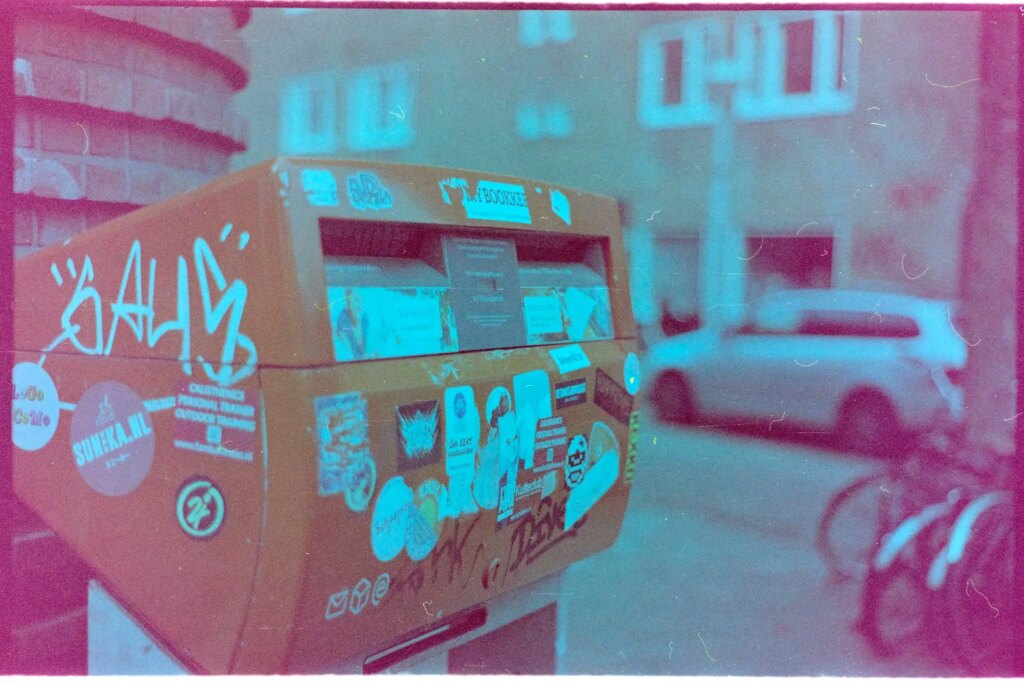 A typical Dutch mailbox: Bright orange, and covered in stickers.