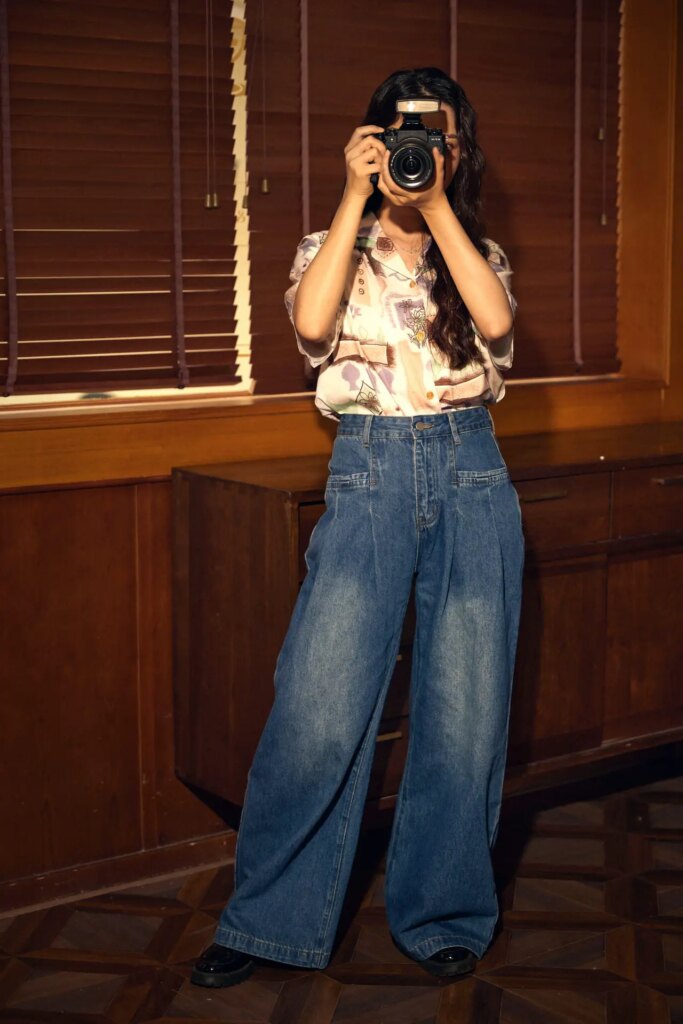 woman taking a photo of the camera with the godox lux junior wearing jeans and blouse