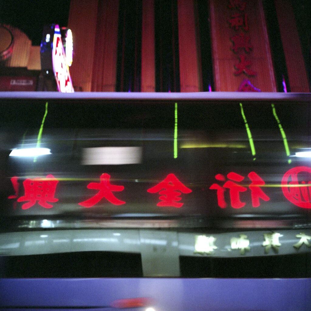 Neon lights reflected in bus windows