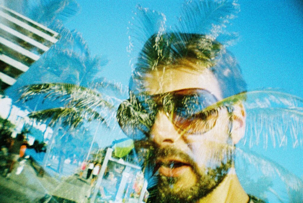 multiple exposure of face with palm trees in background