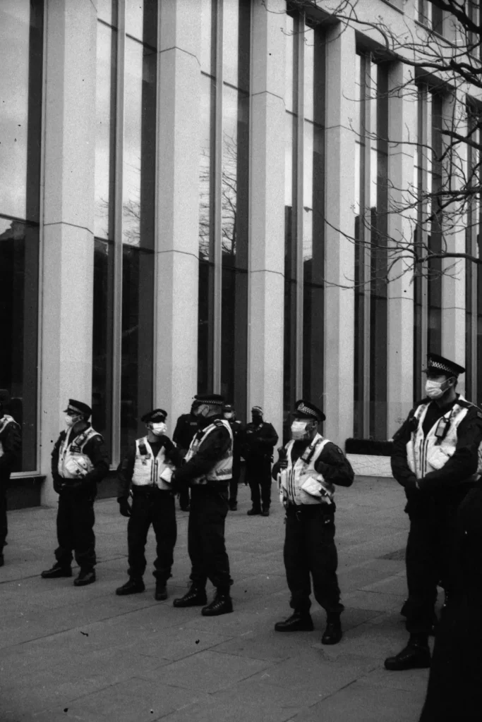 A line of police in front of an office building.
