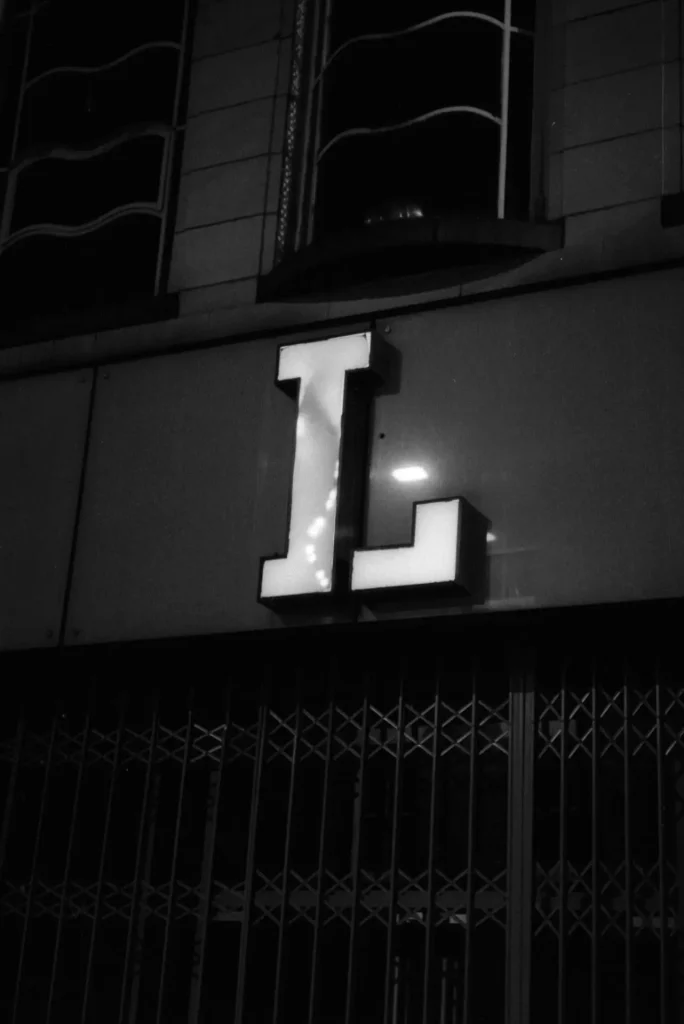 A large illuminated sign of the letter L.
