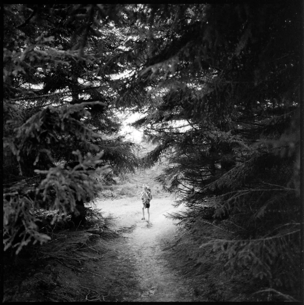 My partner walking in the woods and carrying food for both of us.