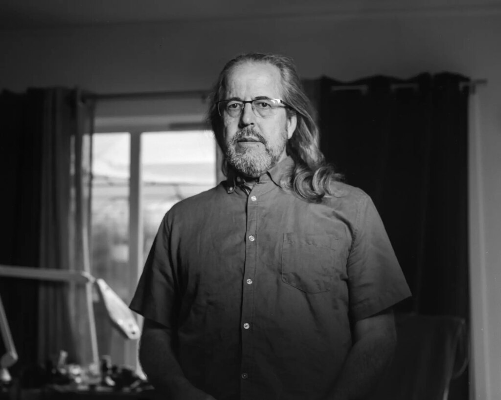 Portrait in a living room using flash and adjusting the shutter speed to make the background darker than the face