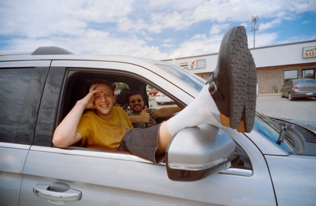 person in car with feet sticking out the window smiling taken on LomoApparat