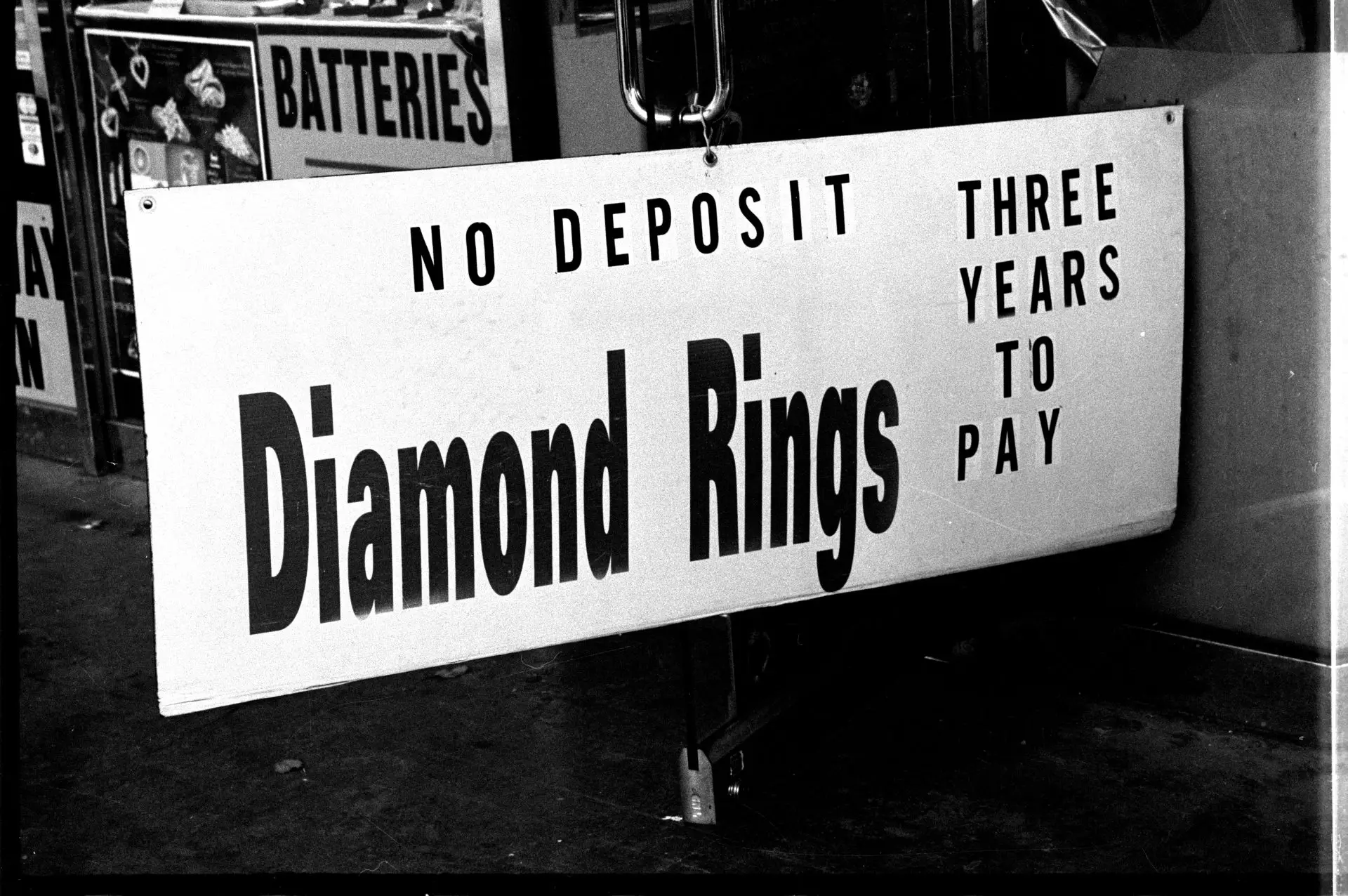 A sign that reads, "DIAMOND RINGS - NO DEPOSIT - THREE YEARS TO PAY" 