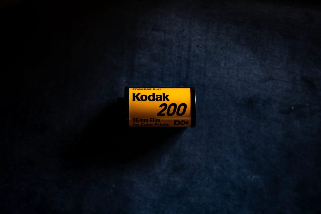 A roll of expired Kodak 200 ISO film against a black background.