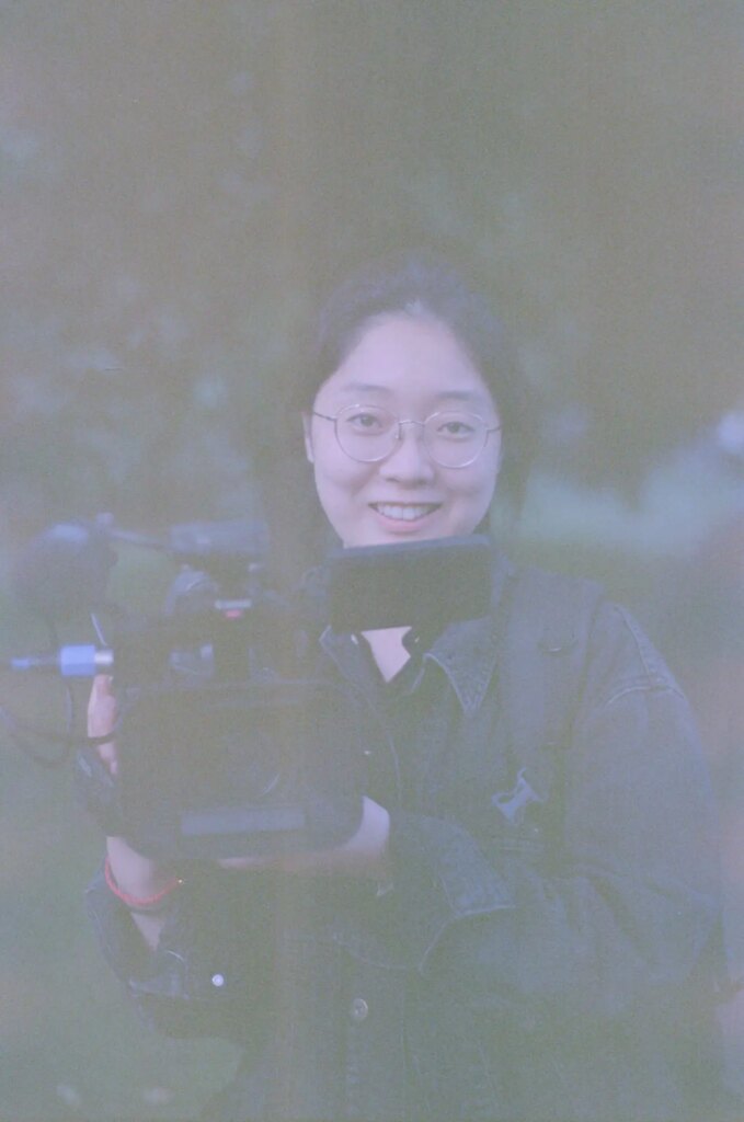 Portrait of a woman holding a video camera.