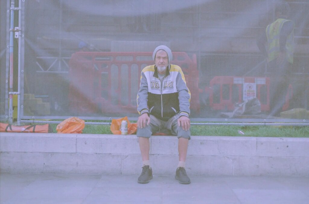 Portrait of a man sat on a wall.