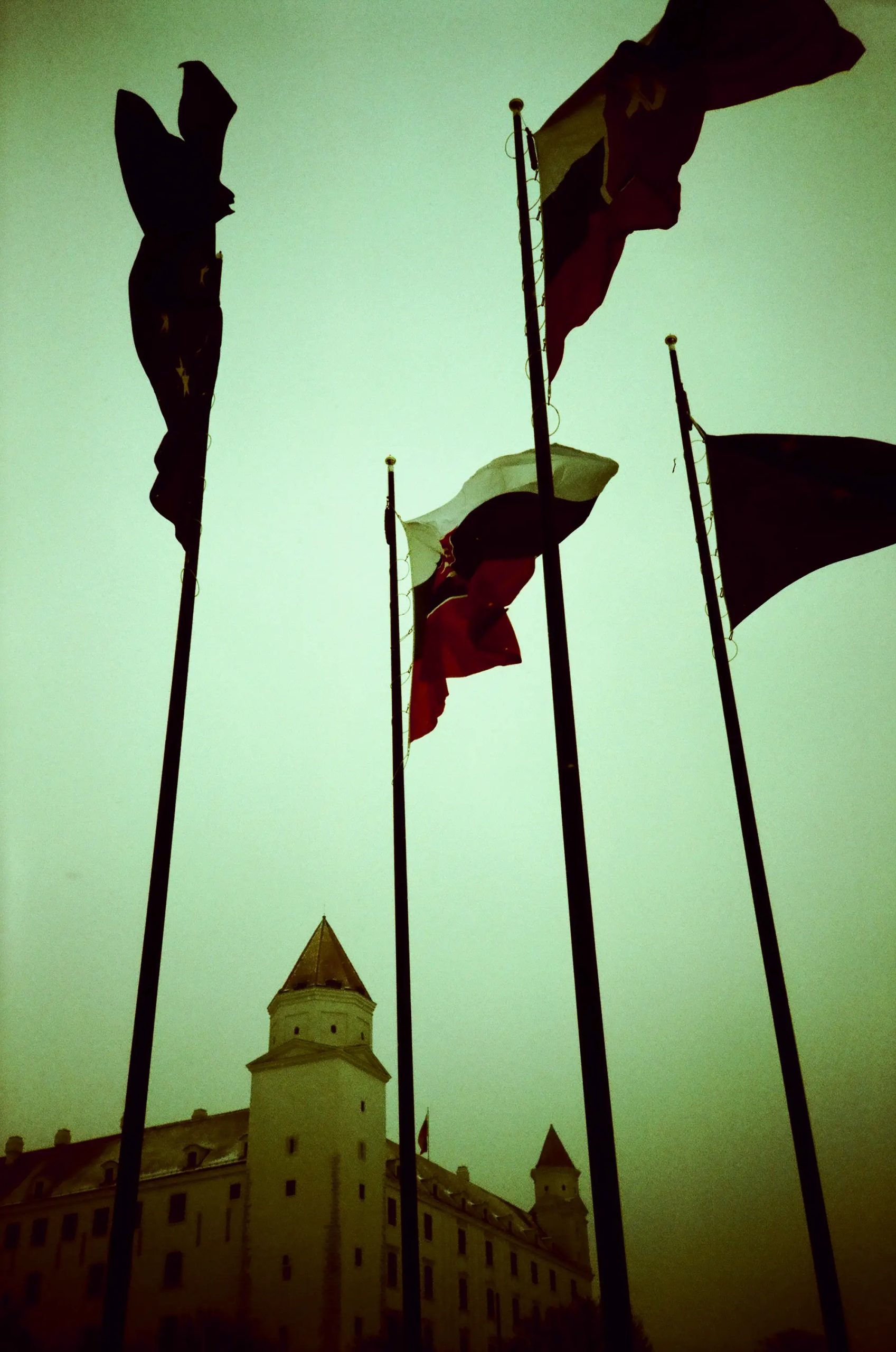 Slovak and European Union flags fly in the wind with the Bratislava Castle in the background. Bratislava, Slovakia, 2014.