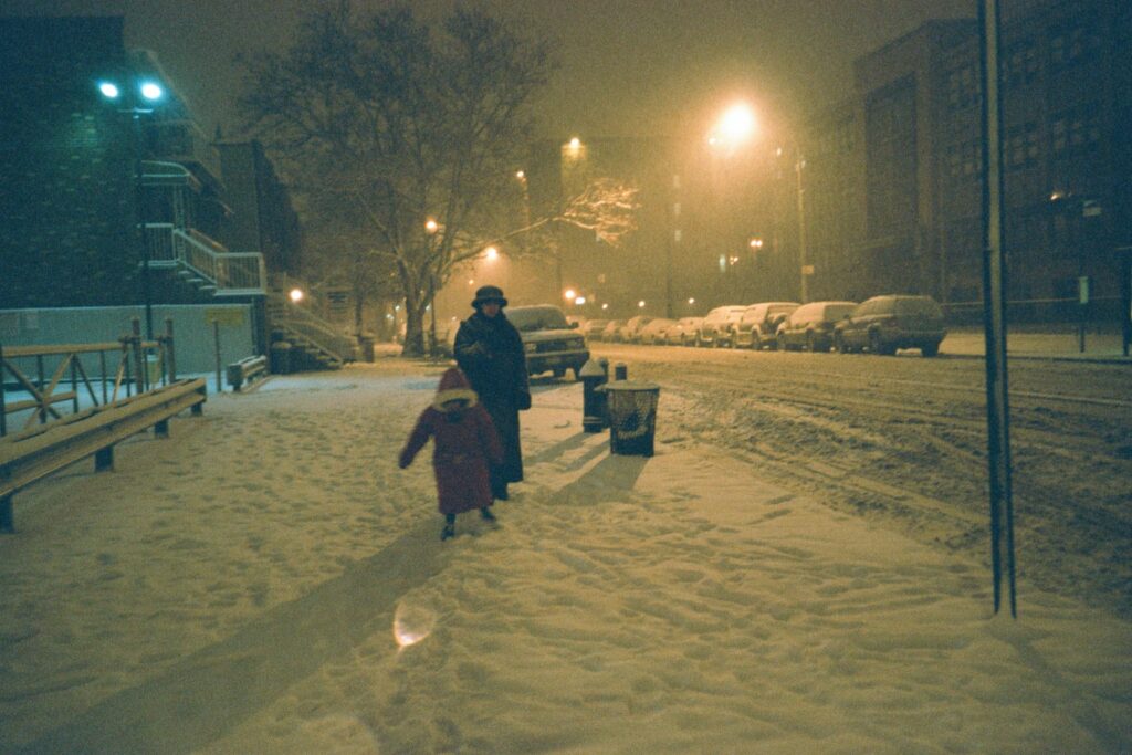 Mom and kid enjoying snow at night