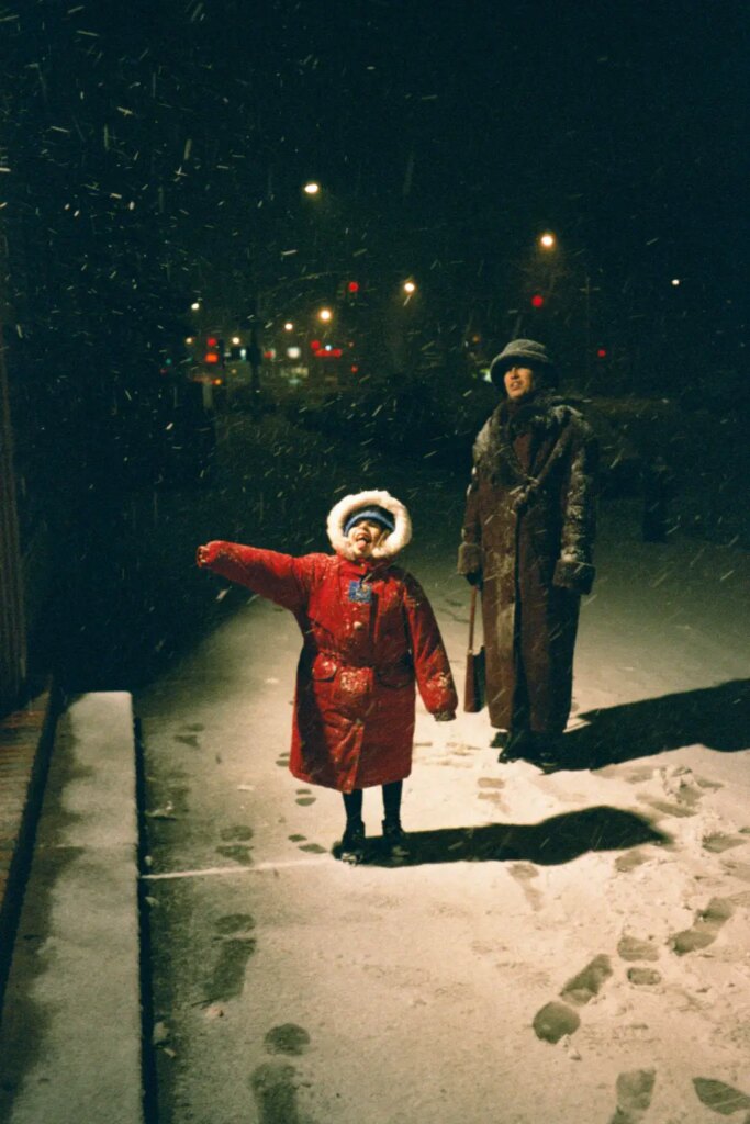Mom and kid enjoying snow at night