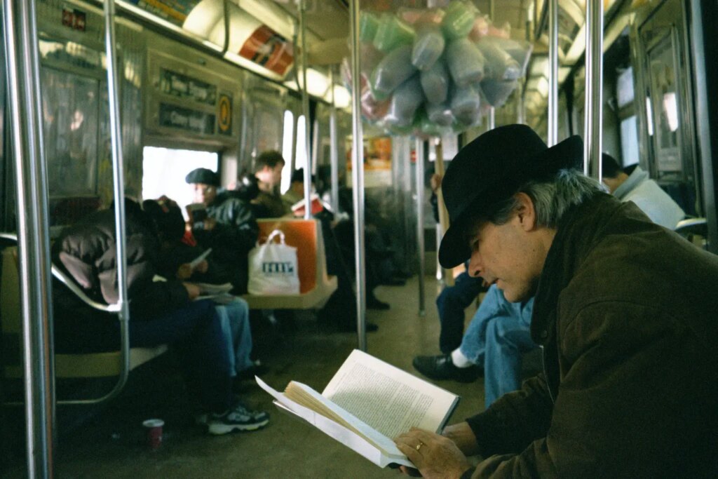 Man reading book on subway