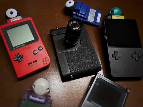 game boy camera M photographed next to traditional gameboys
