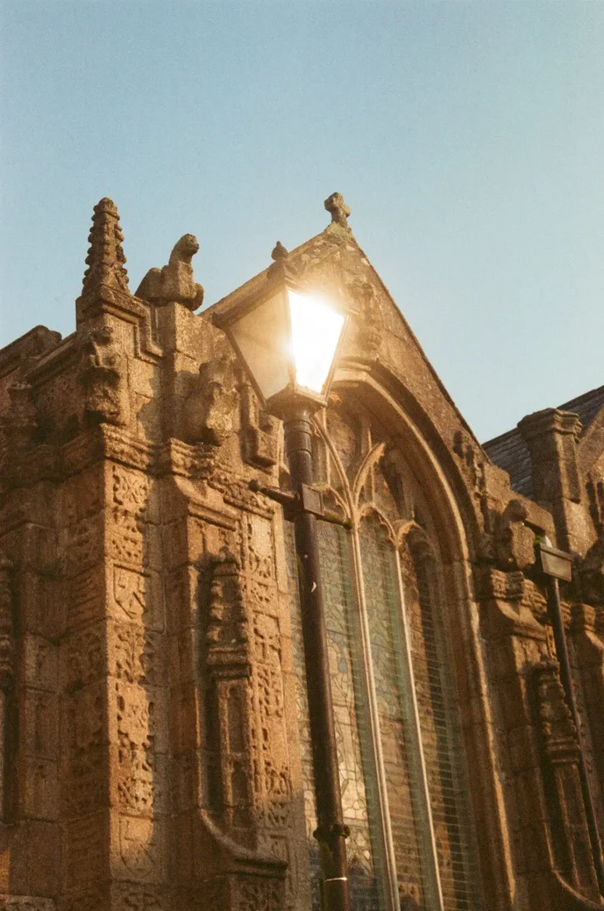 Streetlamp reflecting the sun outside large church window
