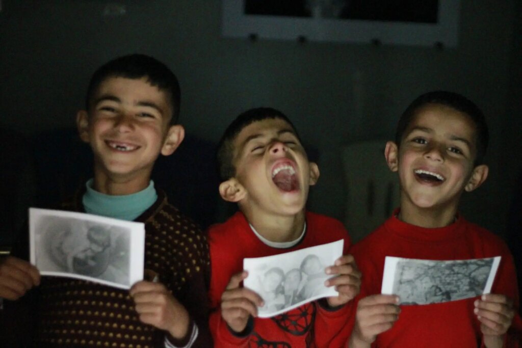 children pose with images they made in darkroom workshop