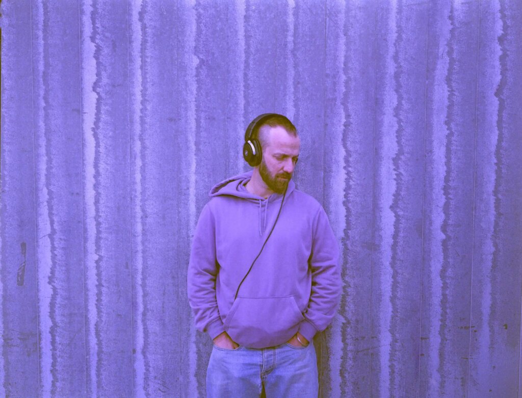 Portrait of man wearing headphones in front of striped wall, New 120 Specialty Film - 460nm