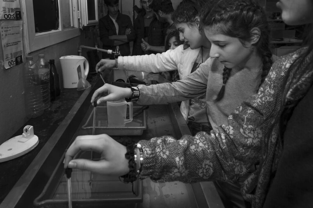 Students in darkroom learning to process and print analogue film photos