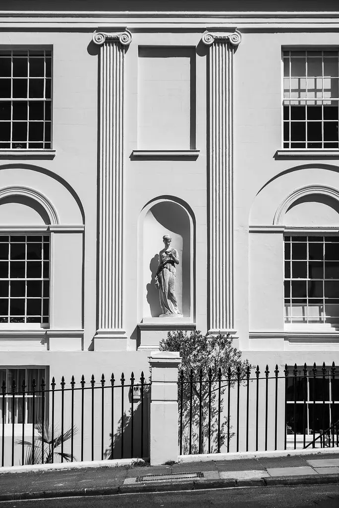 Interesting facade featuring a Greek looking sculpture of a woman with a water jug