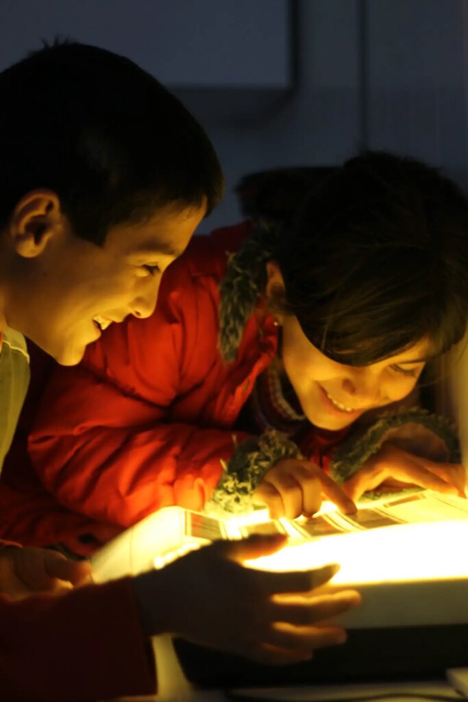 children practice printing photos in darkroom workshop