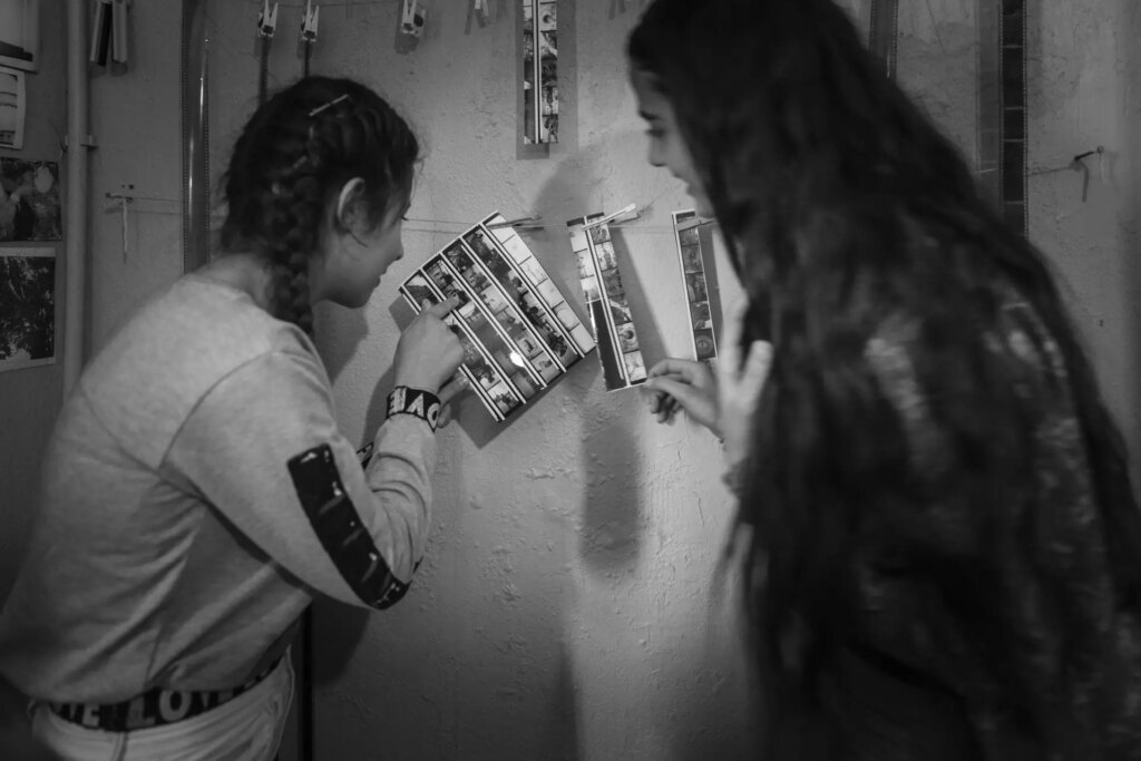 Students in darkroom learning to process and print analogue film photos