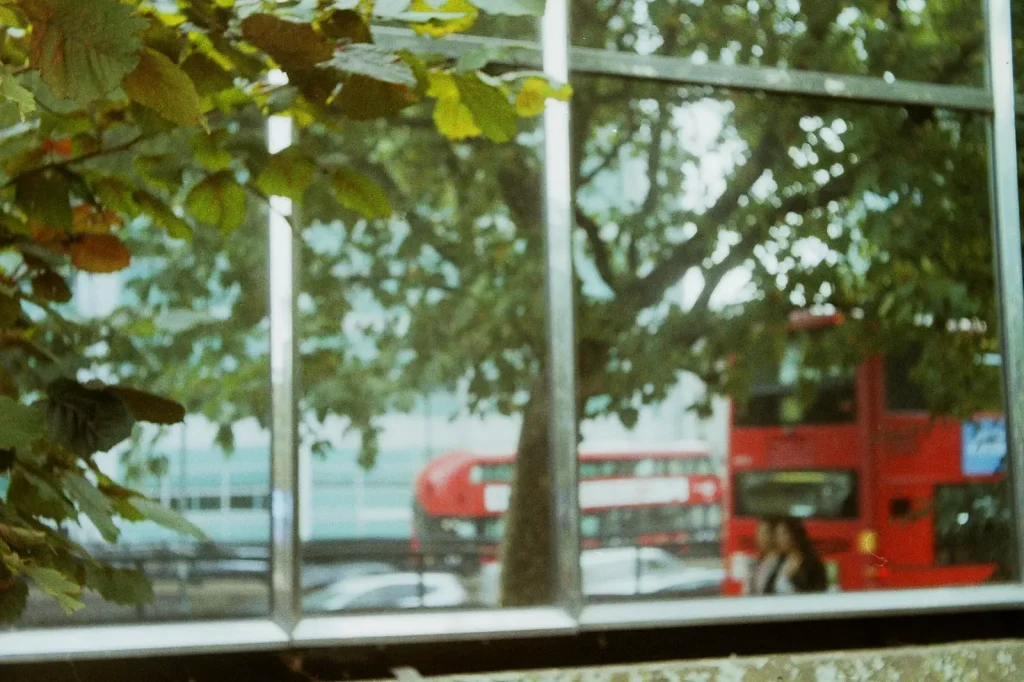 photo of a red bus reflected in a window