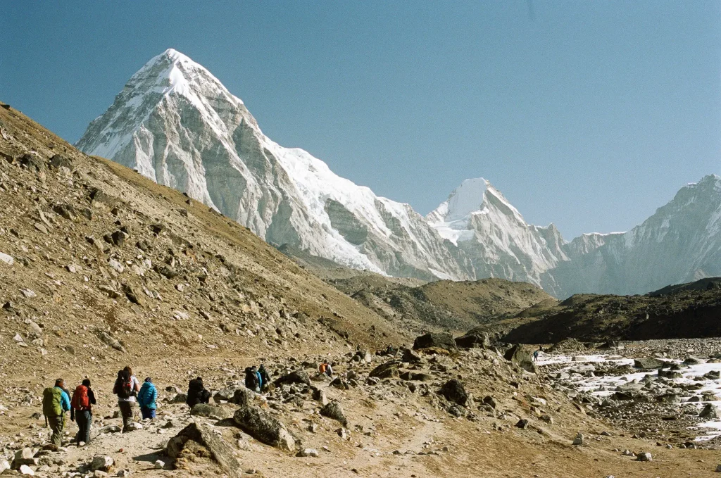 View of mountains with people walking up a valley