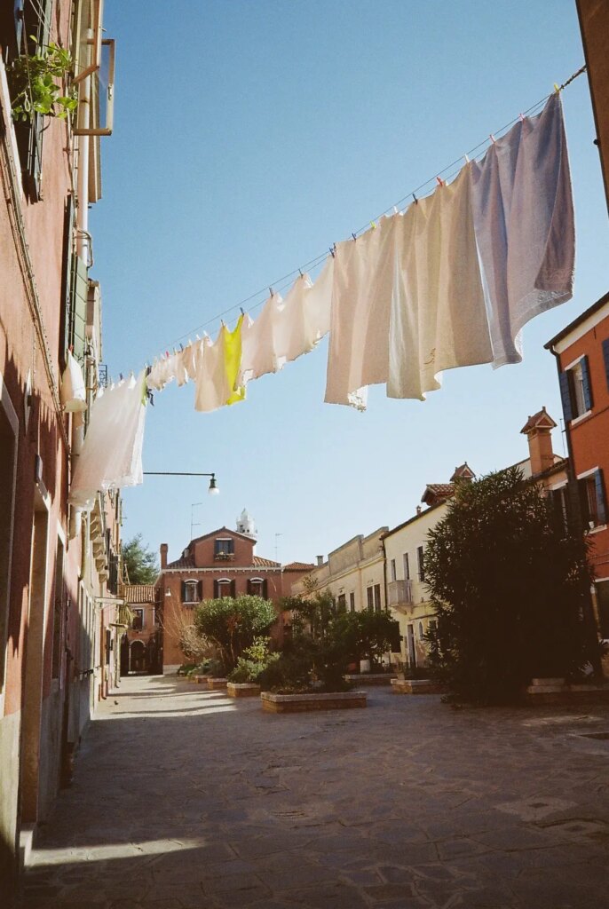 clean clothes floating in the air in between streets, with a colorful plaza as the background.