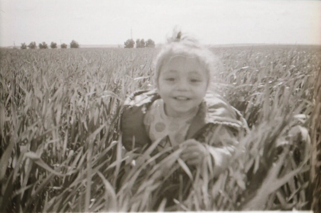 young child running through high grass in a field