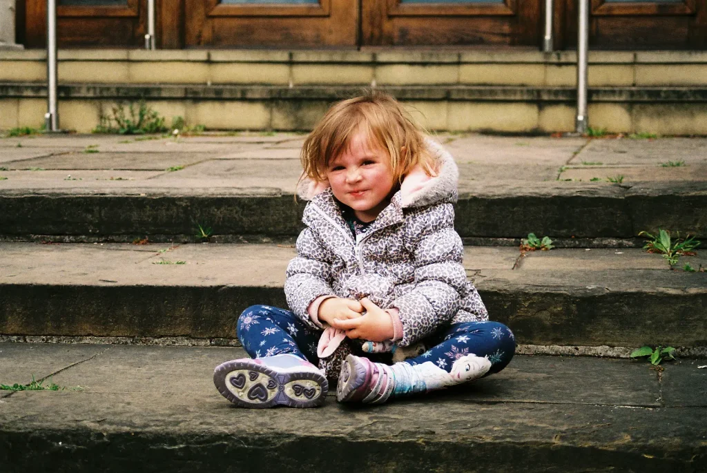 photo of young child sitting on steps