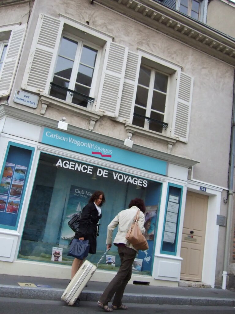 Two women in front of a travel agency.
