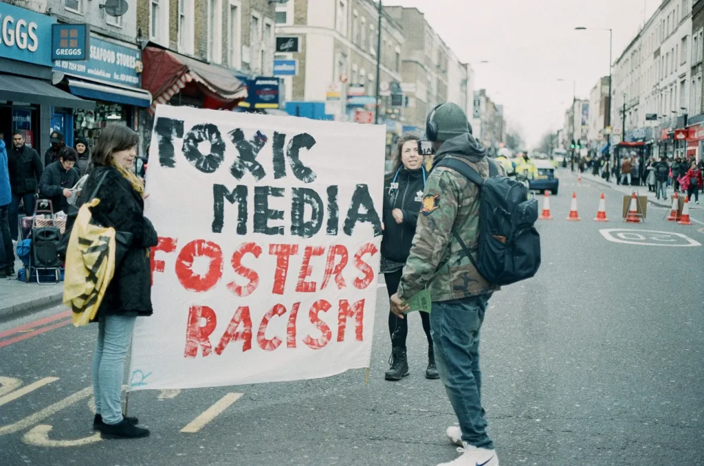 Two people holding a banner in the middle of a traffic free street