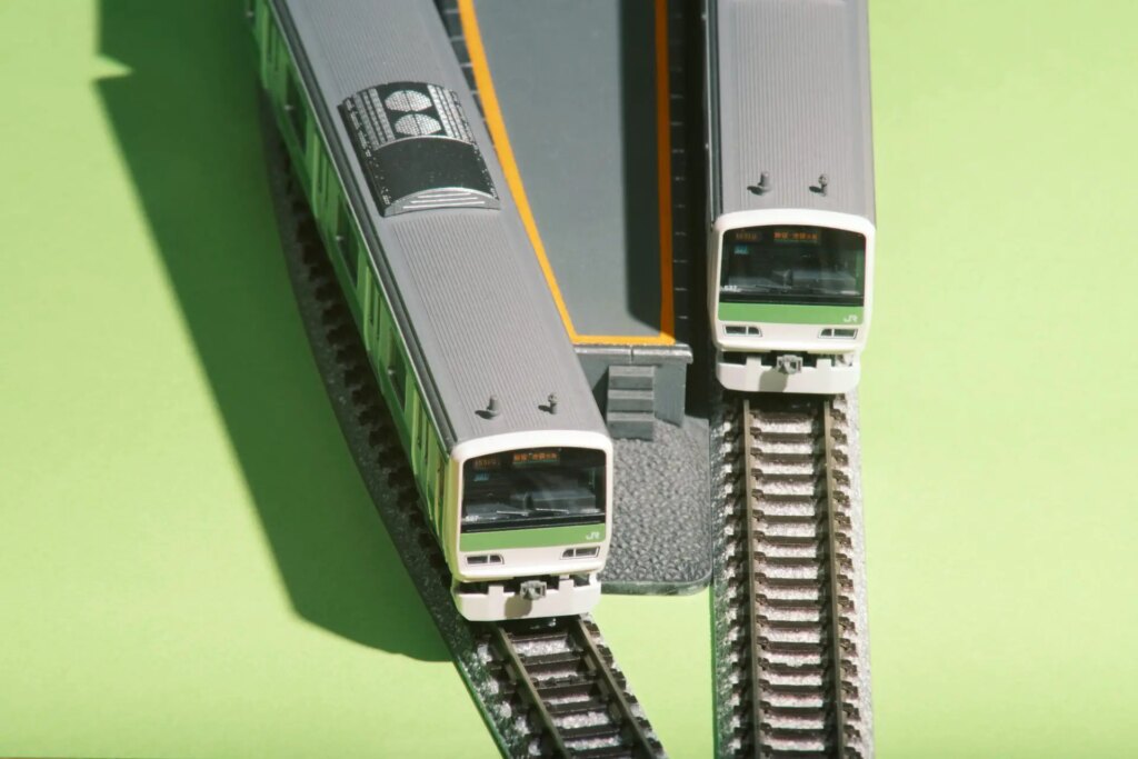 Two toy trains passing at a station.