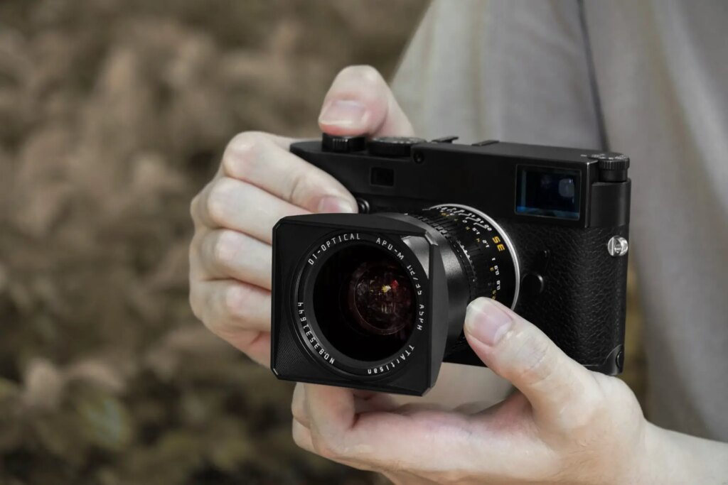 hands holding a camera body with the 35mm f2 leica m mount ttartisan lens attached