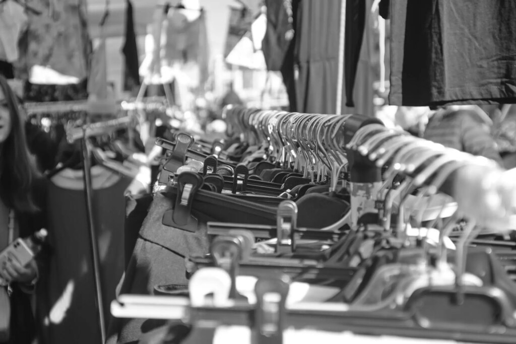 Clothes on hangers at a flea market, with a shallow depth of field.