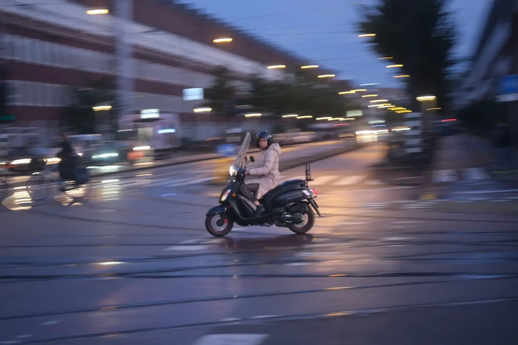 Motor scooter passing through an intersection in the early morning