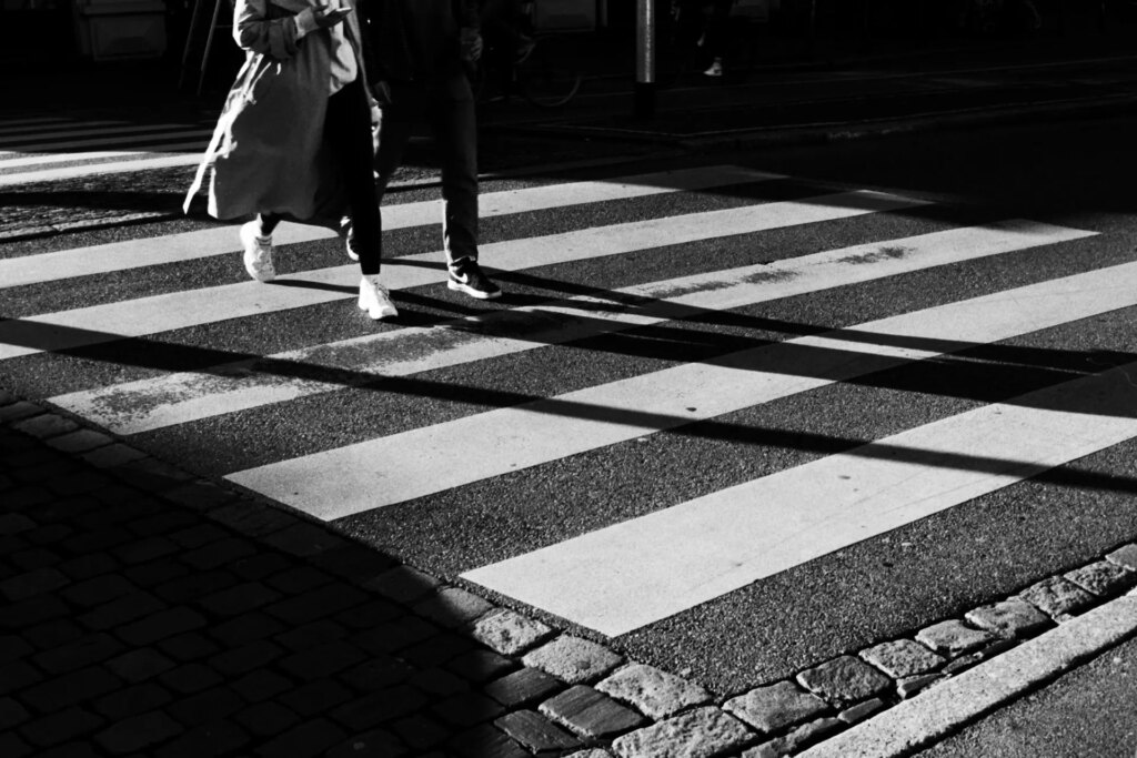 A couple walks over A pedestrian crossing.