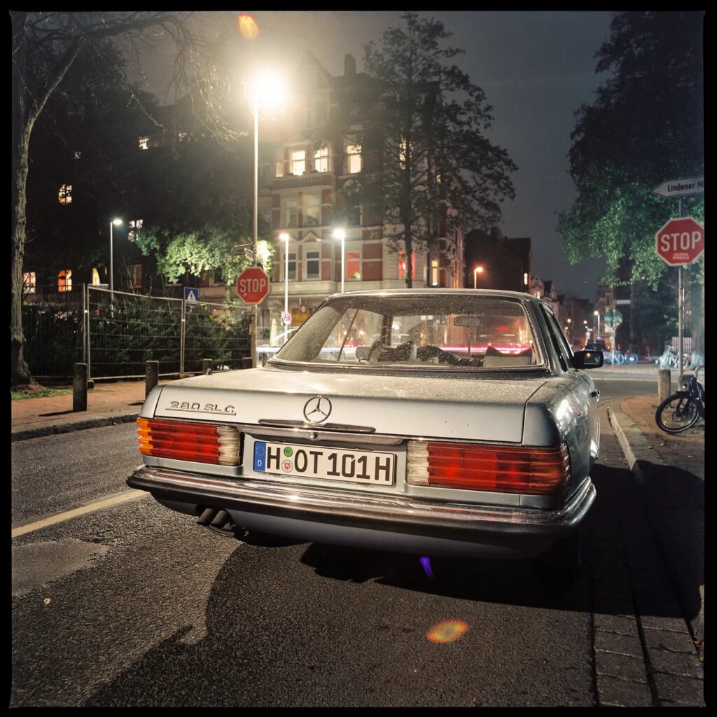 medium format photograph of the rear end of an old Mercedes SL car, shot at night with a Hasselblad Distagon 50mm f/4 lens