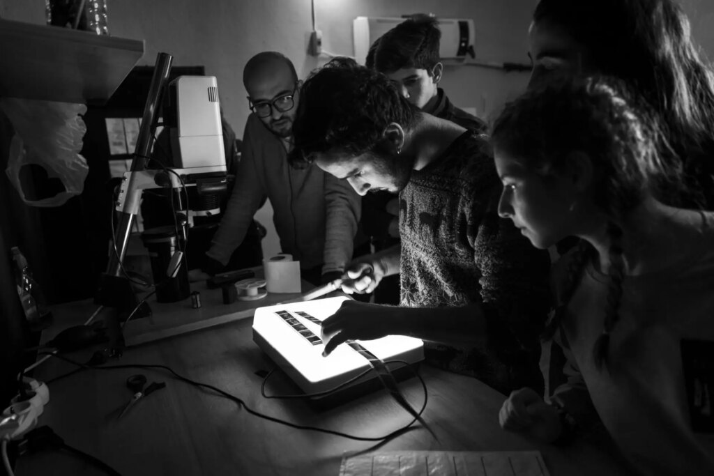 Students in darkroom learning to process and print analogue film photos